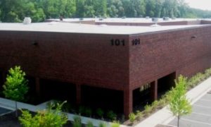 A brick commercial building with a PVC flat roofing system.
